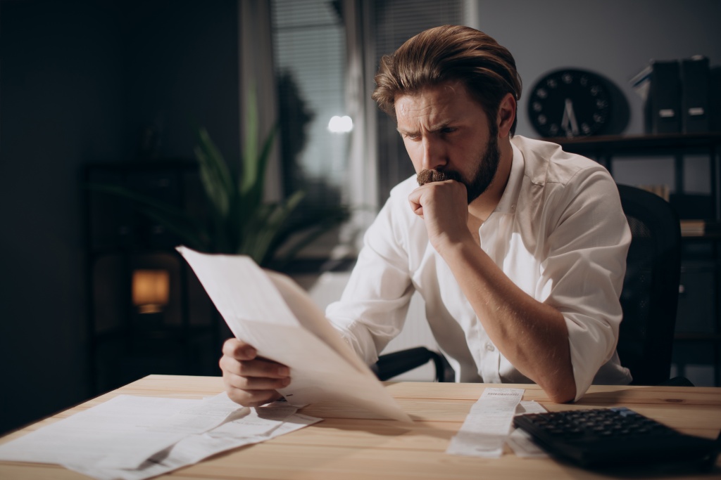 concentrated-businessman-reading-documents-dark-office.jpg мужчина